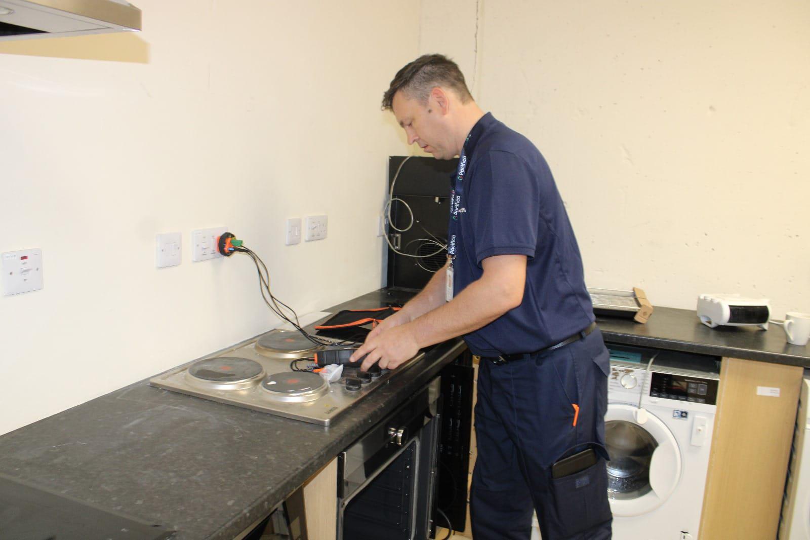 ASAP Repairs technician testing electrical appliances in a kitchen